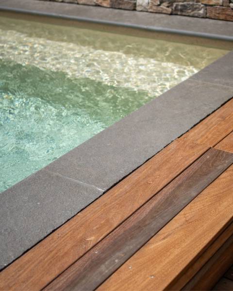 Piscine avec margelle en pierre de Tandur grise à bord arrondi